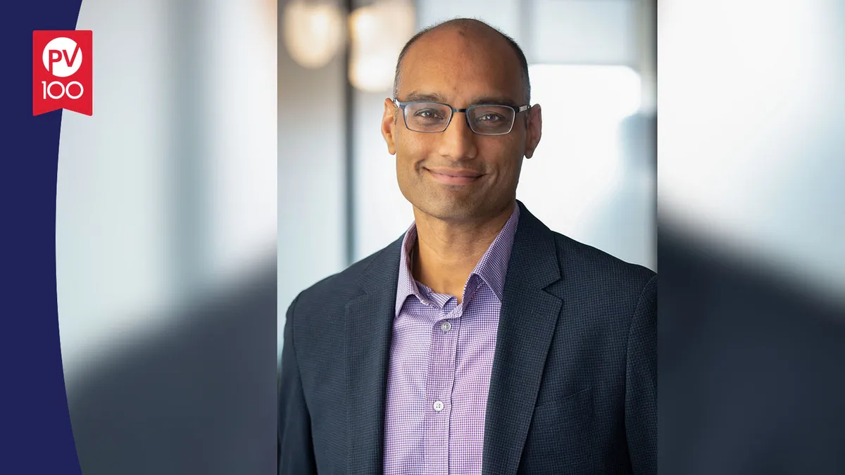 A portrait of Rahul Ballal framed with a banner icon that reads "PV 100"