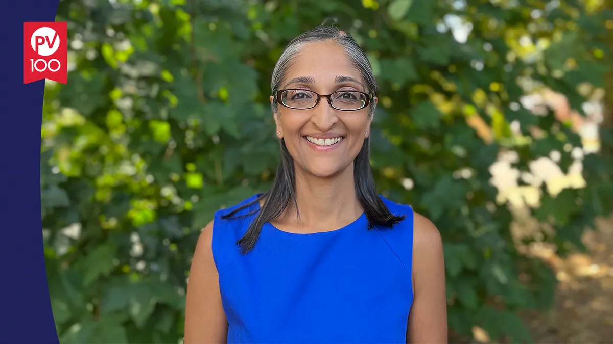 A portrait of Trishna Bharadia framed with a banner icon that reads "PV 100"