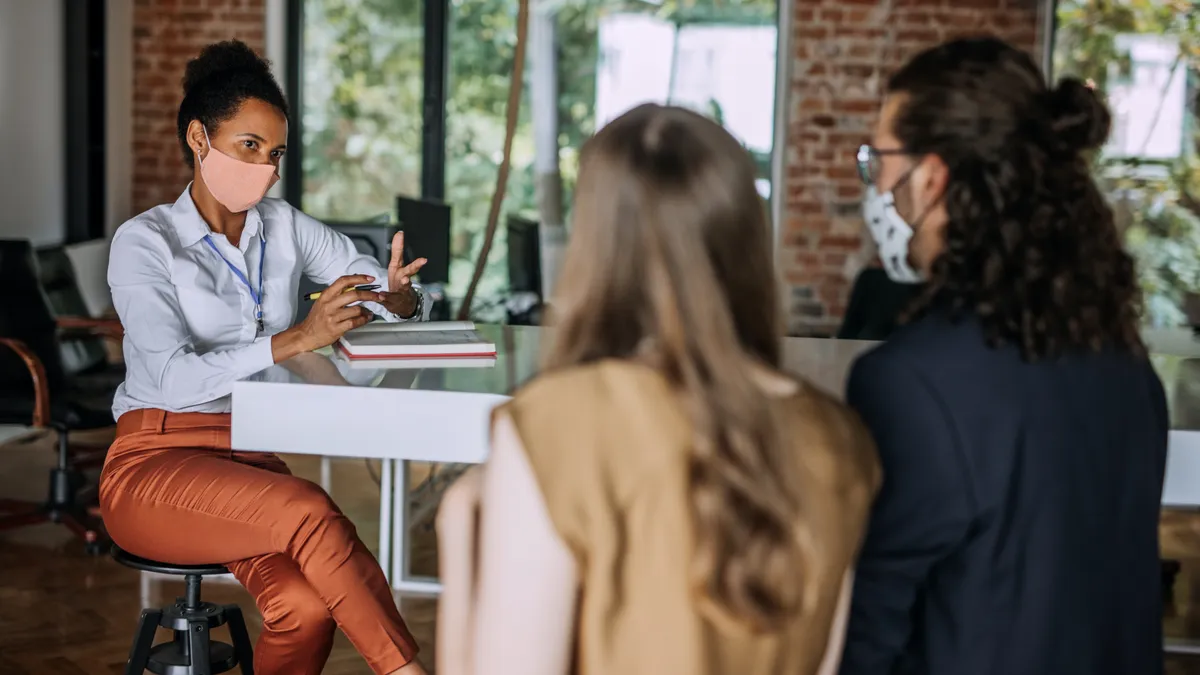 Three people are having an in-office meeting