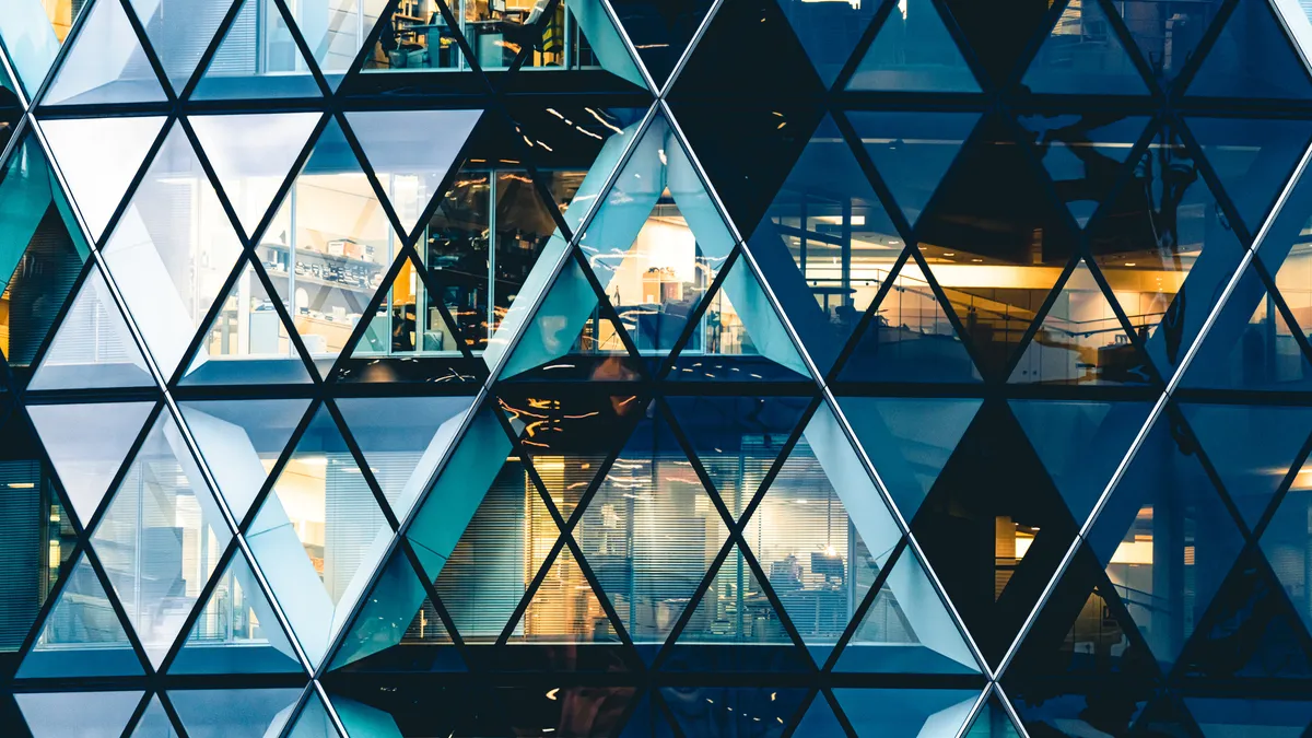 exterior photo of the Gherkin building, looking into lit offices