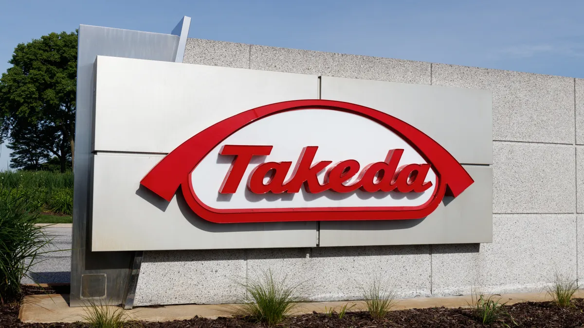 A sign with the logo for the Takeda pharmaceutical company.